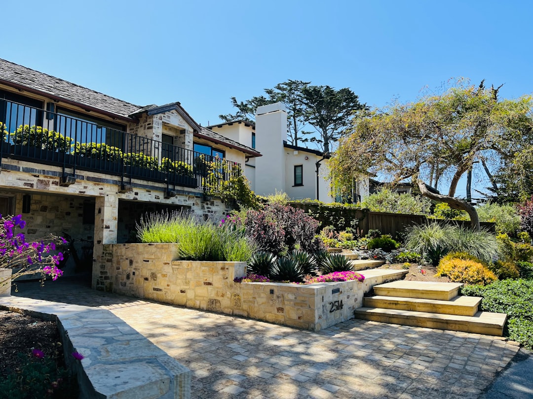 A photo showing a hillside California home build with excavation, retaining walls, and stepped foundation work