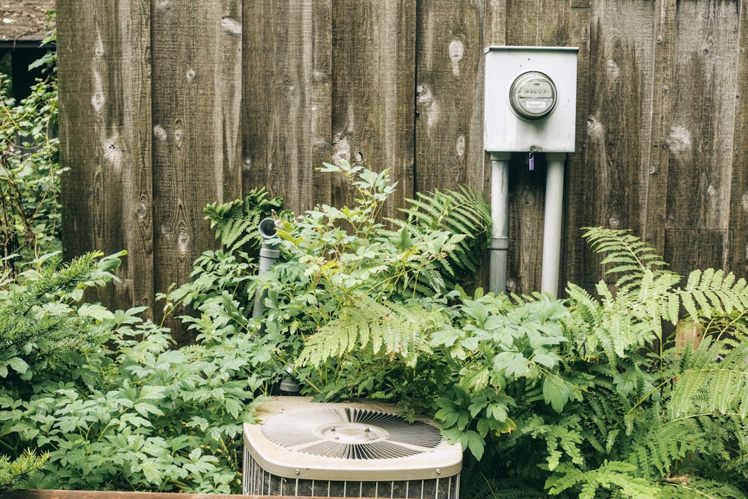 Photo showing an outdoor condenser/heat pump on a new-construction pad beside a newly built home